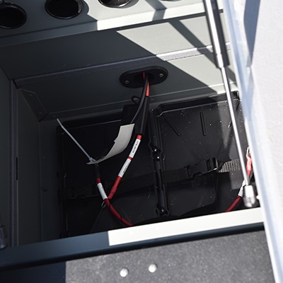 Battery storage compartment including 12V or 24V bow trolling motor plug and receptacles with wiring harness